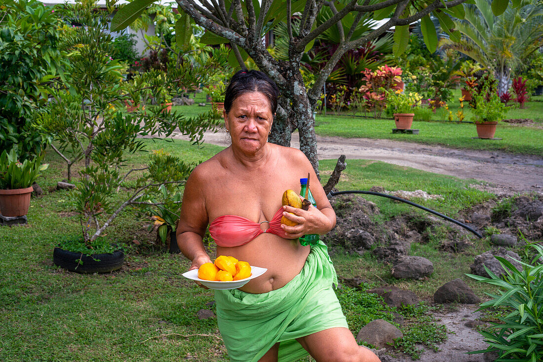 Frau schneidet Mangofrucht mit scharfem Messer in Moorea, Französisch-Polynesien, Gesellschaftsinseln, Südpazifik. Cook's Bay.