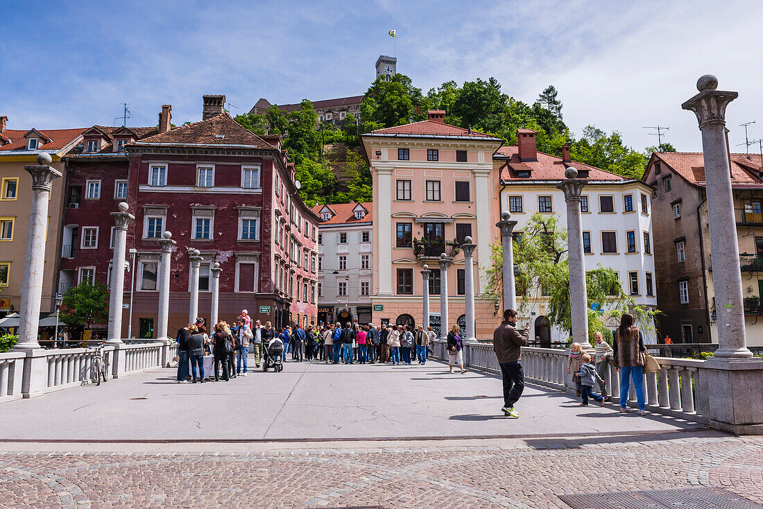 Ljubljana. People walking across the Cobblers Bridge towards Ljubljana Castle, Slovenia, Europe