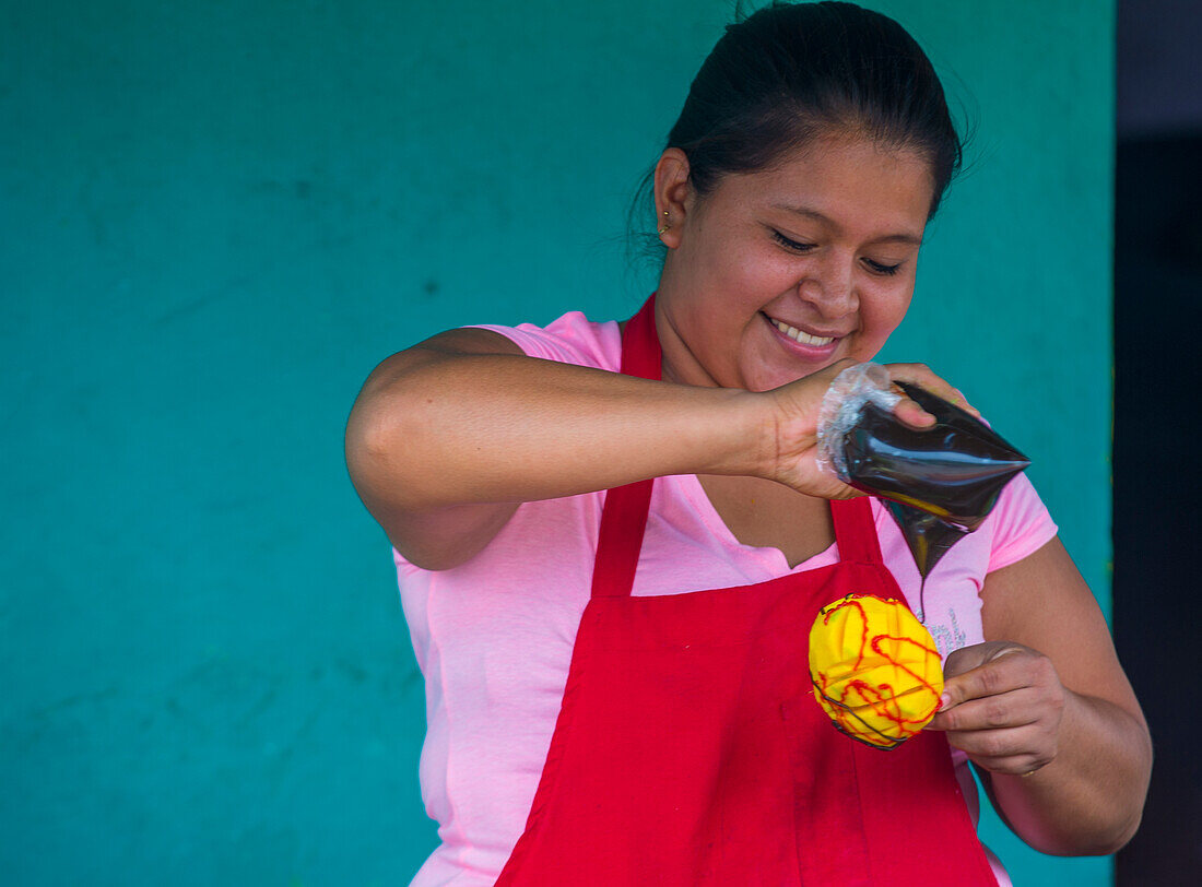 A Salvadoran woman sells mango on a stick during the Flower & Palm Festival in Panchimalco, El Salvador