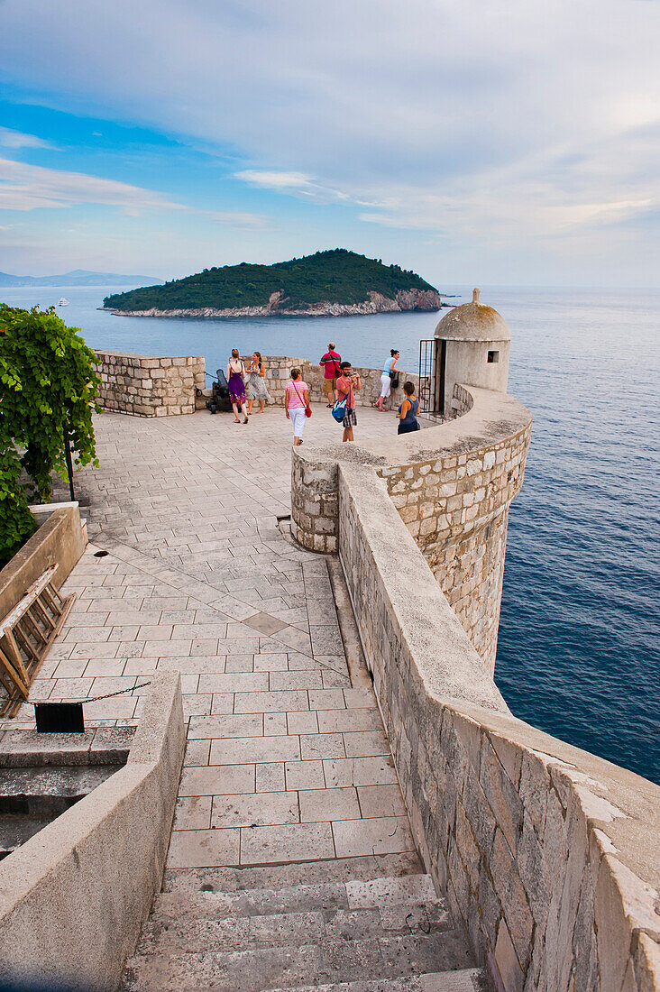 Foto der Stadtmauern von Dubrovnik und der Insel Lokrum, Altstadt von Dubrovnik, Kroatien. Dies ist ein Foto der Stadtmauern von Dubrovnik und der Insel Lokrum. Die Stadtmauern von Dubrovnik sind eines der beliebtesten Ausflugsziele in Dubrovnik, da man von hier aus einen unglaublichen Blick über die gesamte Altstadt von Dubrovnik und die Adriaküste, einschließlich der Insel Lokrum, hat.