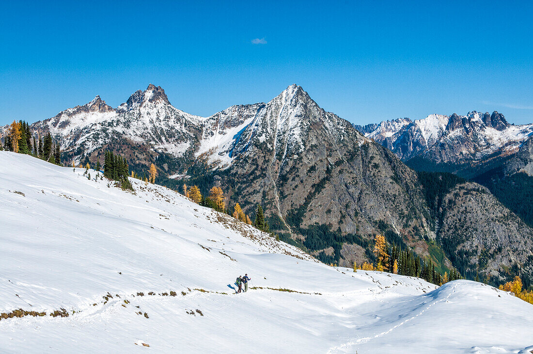 Hikers on Lake Ann - Maple Pass - Heather Pass Loop Trail with view of Cutthroat Peak, Whistler Mountain and the Early Winters Spires in the background; Okanogan-Wenatchee National Forest, Cascade Mountains, Washington.