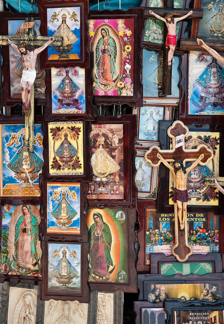 Religiöse Gemälde und Figuren des gekreuzigten Christus werden auf dem Platz vor der Kirche Unserer Lieben Frau von San Juan de los Lagos in der Stadt San Juan de los Lagos, Jalisco, Mexiko, zum Verkauf angeboten.