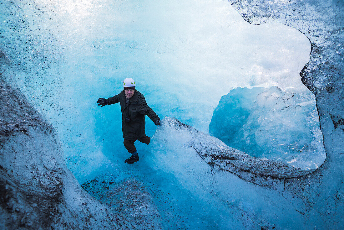 Tourist exploring an ice cave on Breidamerkurjokull Glacier, Vatnajokull Ice Cap, Iceland