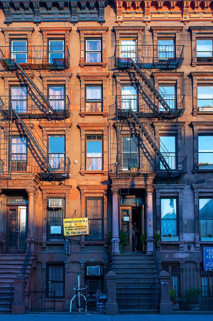 Fire escapes on tenement apartment buildings in Harlem neighborhood, New York City.