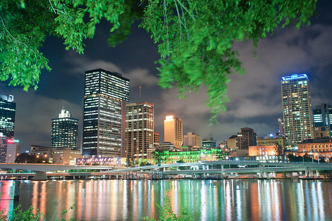 Trees on South Bank and the Reflection of Brisbane Skyline in Brisbane River at Night, Queensland, Australia. This photo of Brisbane River and the reflection of Brisbane city centre Skyline at Night was taken from South Bank.