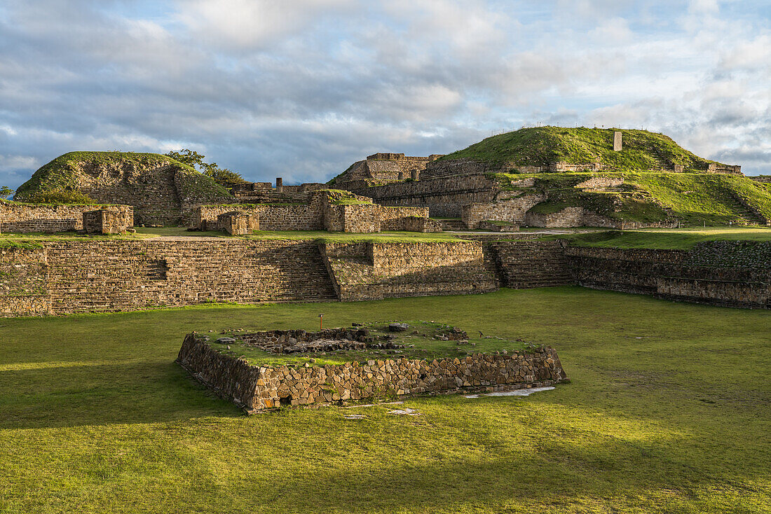 Der versunkene Innenhof mit seinem Altar auf der Nordplattform der präkolumbianischen zapotekischen Ruinen von Monte Alban in Oaxaca, Mexiko. Eine UNESCO-Weltkulturerbestätte. Die Gebäude I, links, und E sind im Hintergrund zu sehen.