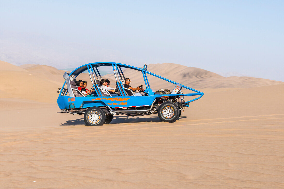 Dune buggying in sand dunes in the desert at Huacachina, Ica Region, Peru