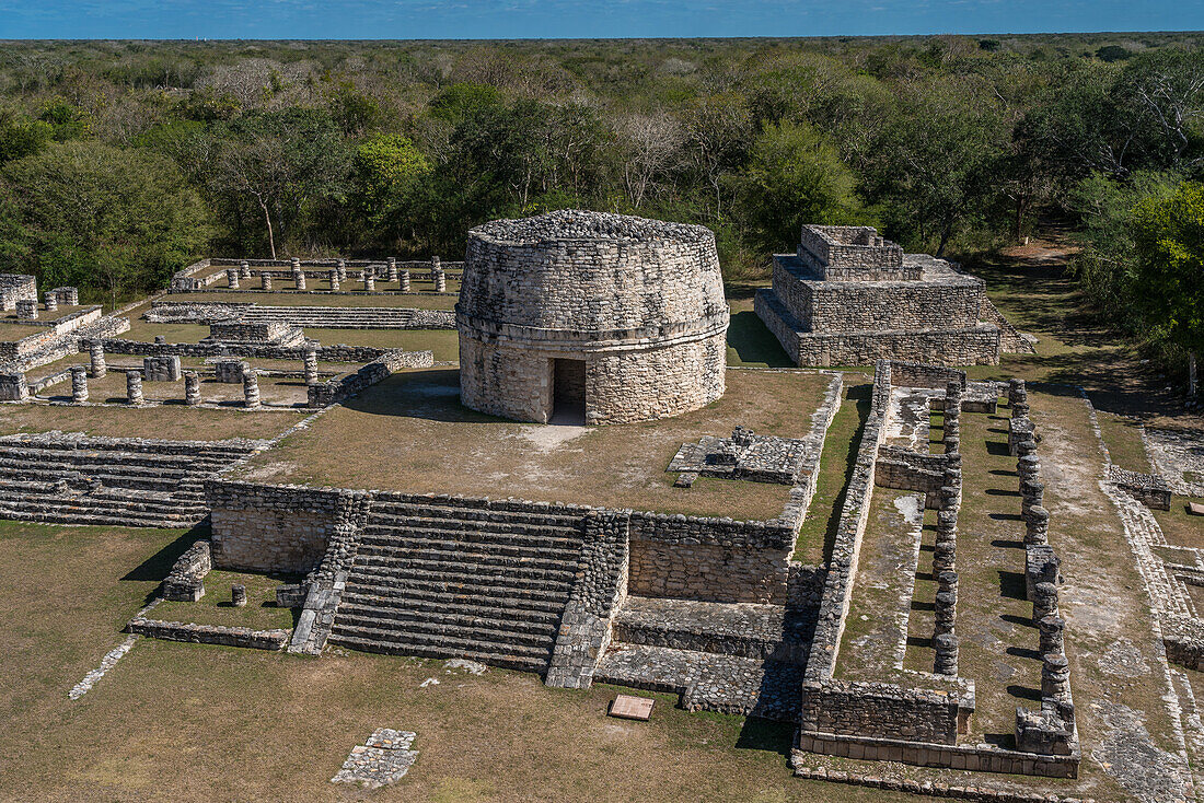 Der Rundtempel oder das Observatorium in den Ruinen der postklassischen Maya-Stadt Mayapan, Yucatan, Mexiko. Rechts sind die Kolonnaden des Tempels der Chaac-Masken zu sehen.