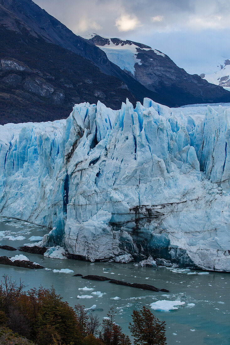 The jagged face of Perito Moreno Glacier and Lago Argentino in Los Glaciares National Park near El Calafate, Argentina. A UNESCO World Heritage Site in the Patagonia region of South America. Icebergs from calving ice from the glacier float in the lake.