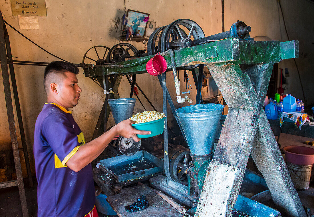 Salvadorianer bei der Arbeit in einer Mais-Tortilla-Teigfabrik in Suchitoto, El Salvador. Mais ist in den mittelamerikanischen Kulturen seit der präkolumbianischen Zeit ein Grundnahrungsmittel.