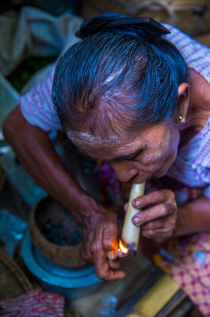 Frau raucht eine Stumpenzigarre auf dem Markt in Bagan, Myanmar