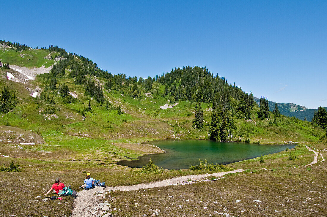 Two women hikers having lunch at Heart Lake; High Divide Trail, Olympic National Park, Washington.