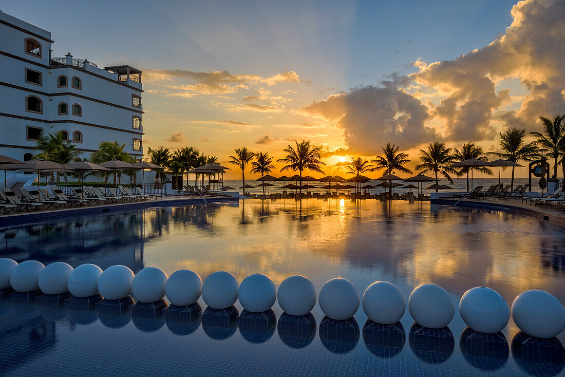 Swimming pool at sunrise, Grand Residences Riviera Cancun, Riviera Maya, Puerto Morelos, Quintana Roo, Yucatan Peninsula, Mexico.
