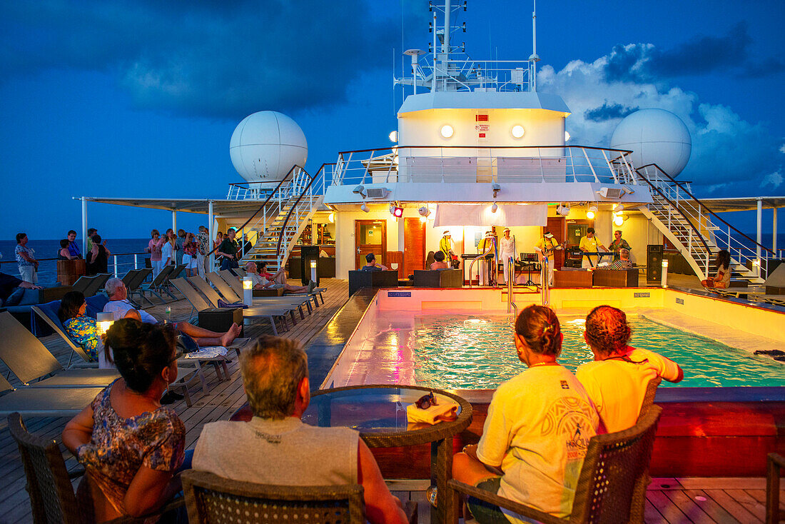 Entertainment group singing in the Paul Gauguin cruise ship. France, French Polynesia, Polynesian, South Pacific.