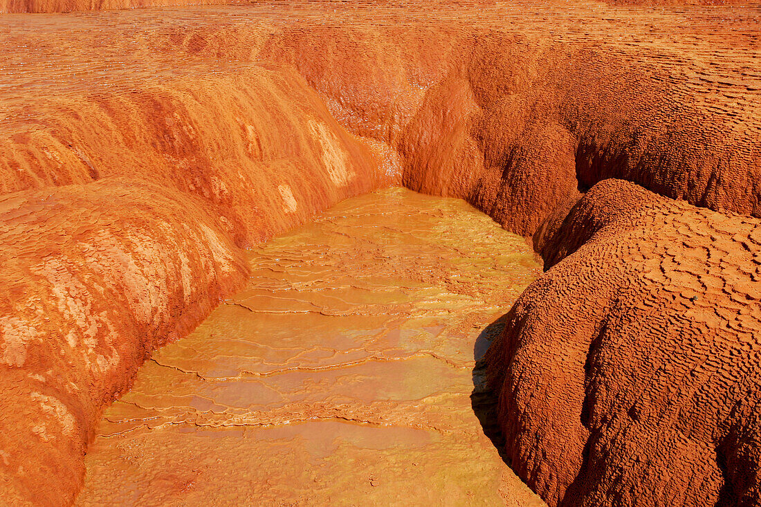 Farbenfrohe Travertinablagerungen um den Crystal Geyser, einen Kaltwassergeysir bei Green River, Utah.