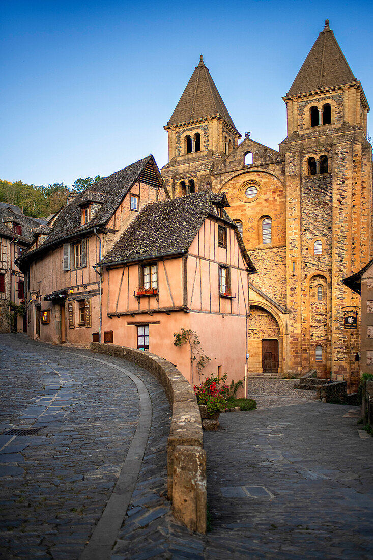 Das kleine mittelalterliche Dorf Conques in Frankreich. Es zeigt dem Besucher seine Abteikirche und die mit Schieferdächern gedeckten Häusergruppen. Kreuzung von engen Gassen und Monolith für die Gefallenen des Krieges im alten mittelalterlichen Dorf Conques am Ufer des Flusses Dordou