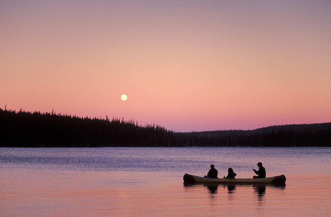People fishing in canoe with full moon rising, Olallie Lake, Mt. Hood National Forest, Cascade Mountains, Oregon.
