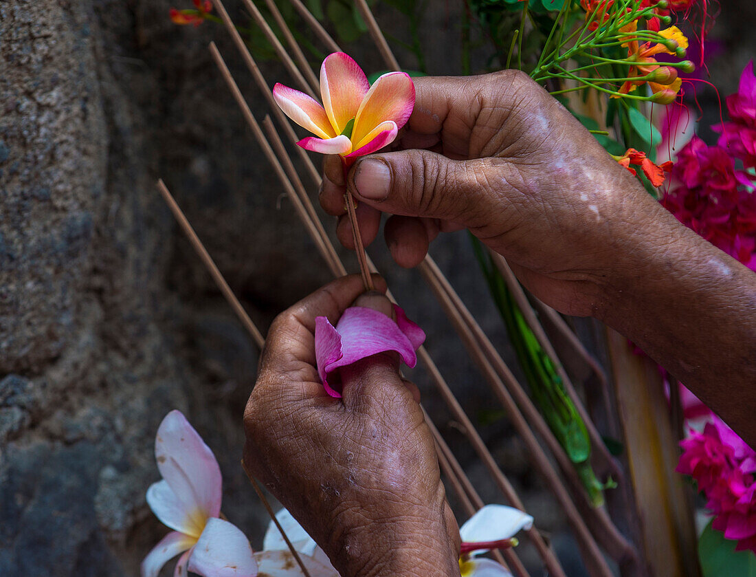 Close up on a Salvadoran woman hands decorates palm fronds with flowers during the Flower & Palm Festival in Panchimalco, El Salvador on May 08 2016