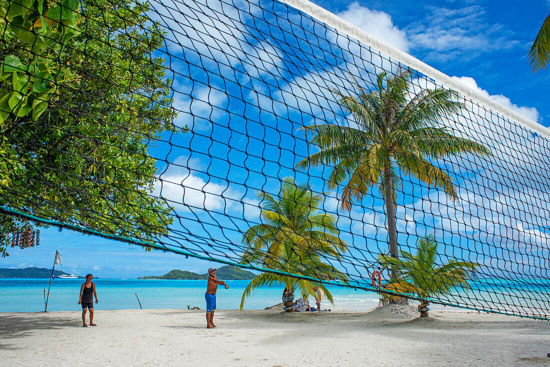 Volleyball am Strand der Insel Motu Tevairoa, einer kleinen Insel in der Lagune von Bora Bora, Gesellschaftsinseln, Französisch-Polynesien, Südpazifik.