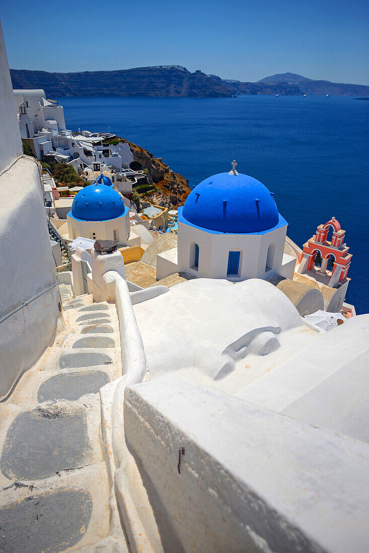 Hillside buildings with traditional church blue domes in Oia, Santorini, Greek Islands, Greece