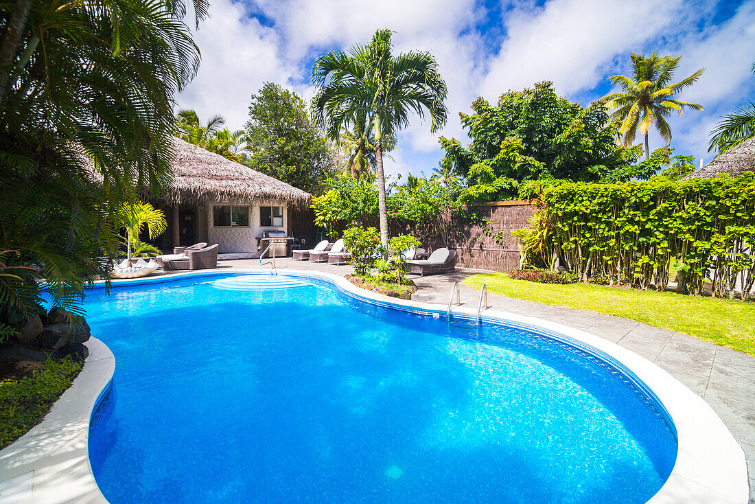 Schwimmbadbereich mit tropischen Palmen in einem Luxushotel, Titikaveka, Rarotonga, Cookinseln, Südpazifik
