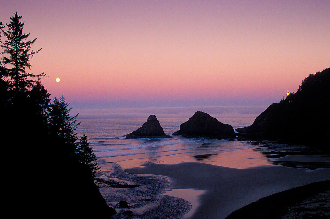 Heceta Head Leuchtturm und Vollmond über dem Meer; Devils Elbow State Park, Küste von Oregon.