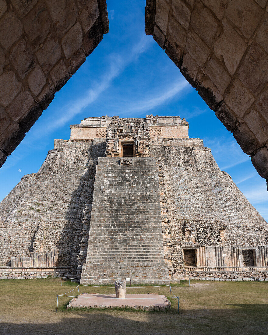 The west facade of the Pyramid of the Magician, also known as the Pyramid of the Dwarf, faces into the Quadrangle of the Birds. It is the tallest structure in the pre-Hispanic Mayan ruins of Uxmal, Mexico, rising about 35 meters or 115 feet. The temple at the top of the stairs is built in the Chenes style, while the upper temple is Puuc style.