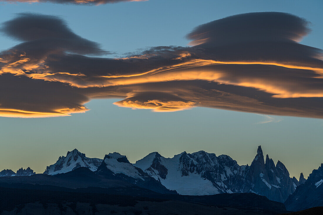 Colorful lenticular clouds at sunset over the Adela Massif and Cerro Torre. Los Glaciares National Park near El Chalten, Argentina. A UNESCO World Heritage Site in the Patagonia region of South America.