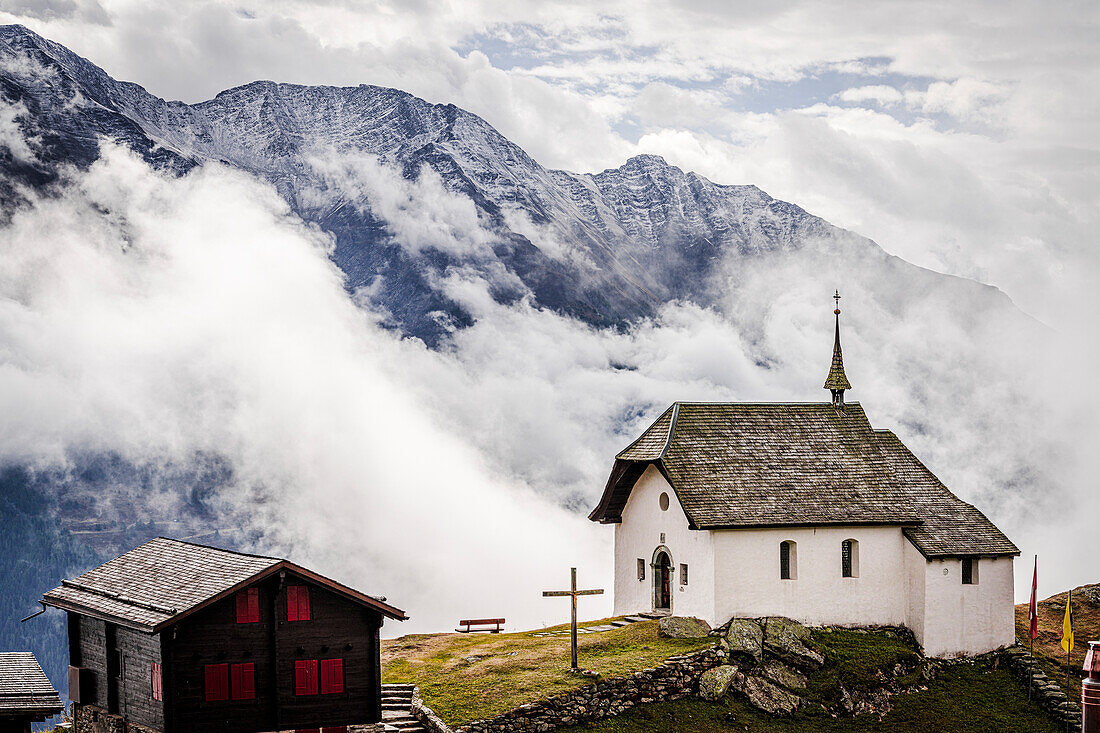 Nebliger Himmel über der kleinen Kirche im Alpendorf Bettmeralp, Kanton Wallis, Schweiz, Europa