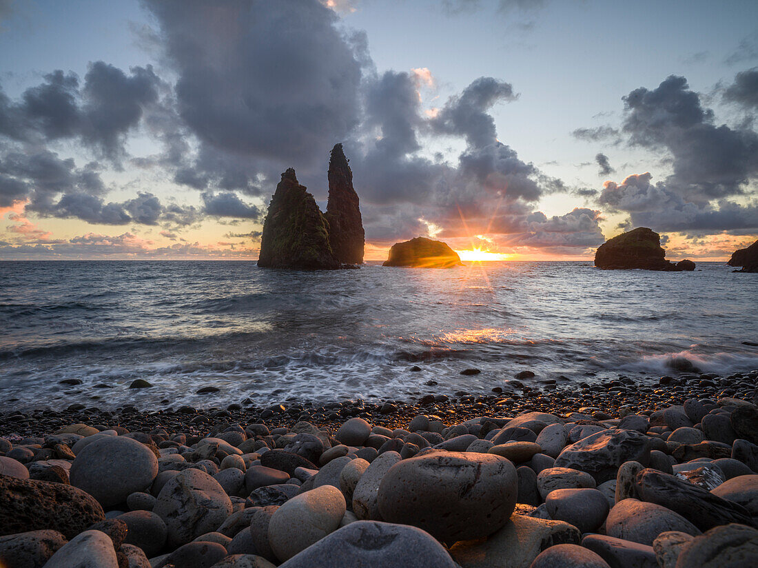 Sonnenaufgang unter den Felsen vom Kieselstrand der Bahia da Alagoa, Insel Flores, Azoren, Portugal, Atlantischer Ozean, Europa
