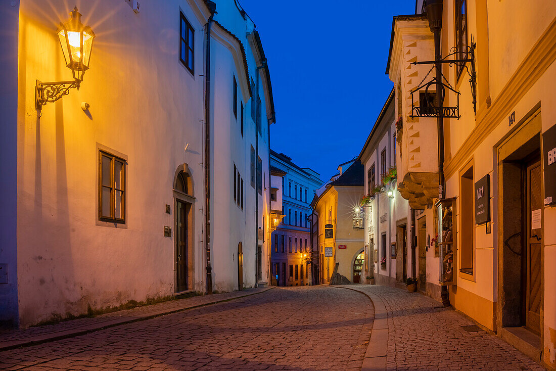 Beleuchtete Straßenlampe in einer leeren Straße im historischen Zentrum in der Dämmerung, UNESCO-Welterbe, Cesky Krumlov, Südböhmische Region, Tschechische Republik (Tschechien), Europa