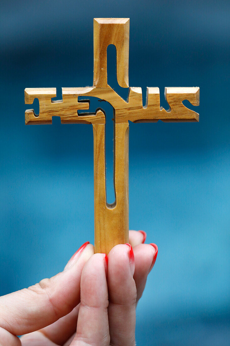 Frau hält ein christliches Holzkreuz mit dem Namen Jesus, Symbol für Religion und Glauben, Vietnam, Indochina, Südostasien, Asien