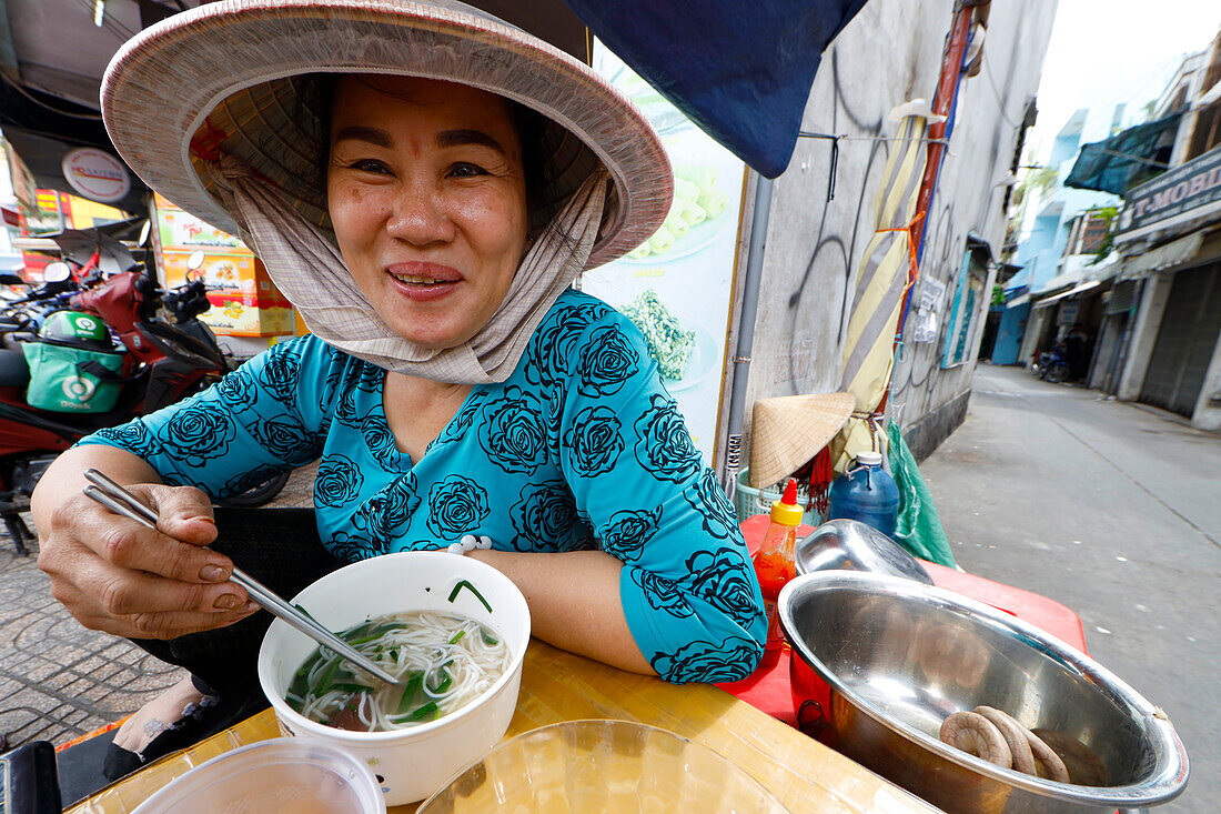 Frau isst traditionelle vietnamesische Suppe (Hu Tieu), Ho Chi Minh Stadt, Vietnam, Indochina, Südostasien, Asien
