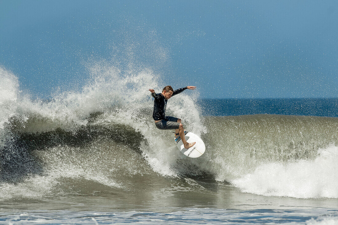 Shortboard-Surfer reitet auf einer Welle an diesem schnell wachsenden Surfstrand und Yoga-Ziel, Playa Guiones, Nosara, Guanacaste, Costa Rica, Mittelamerika