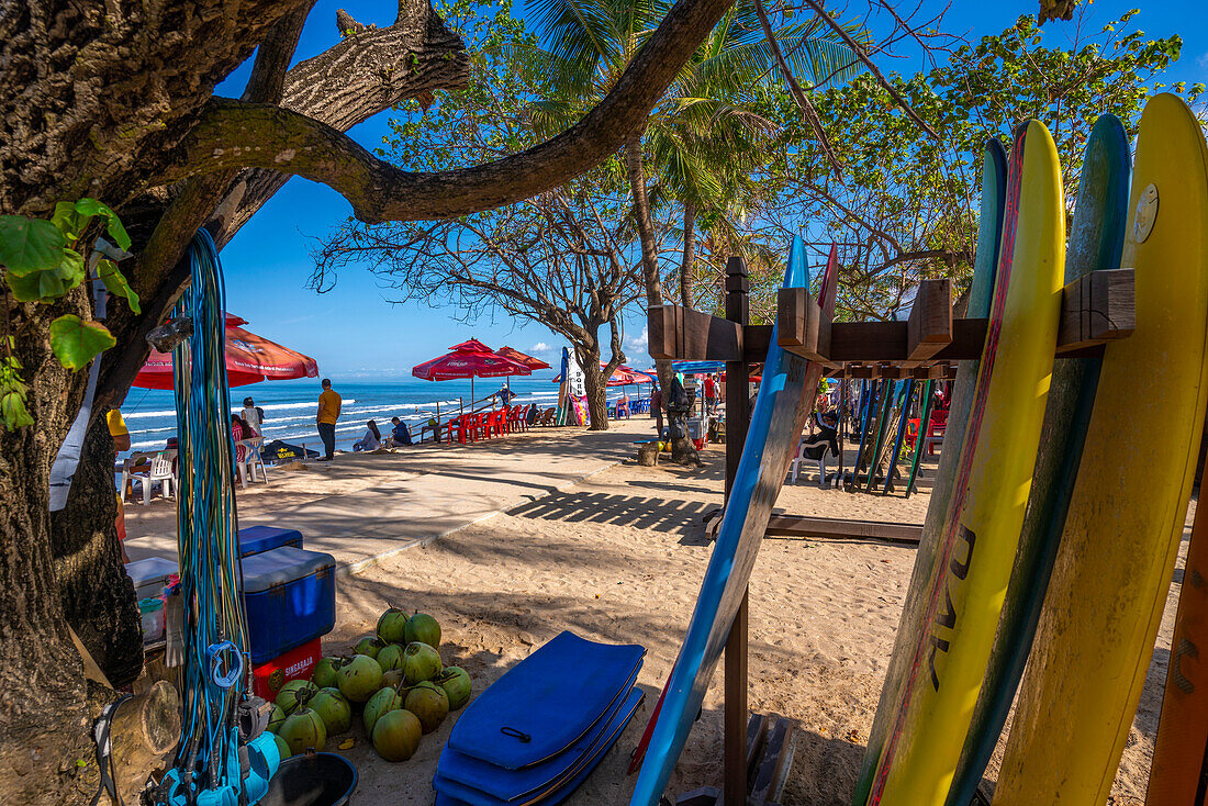 Blick auf Surfbretter und Verkäufer am sonnigen Morgen am Kuta Beach, Kuta, Bali, Indonesien, Südostasien, Asien