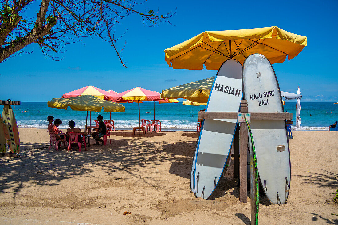 Blick auf Sonnenschirme und Surfbretter an einem sonnigen Morgen am Kuta Beach, Kuta, Bali, Indonesien, Südostasien, Asien