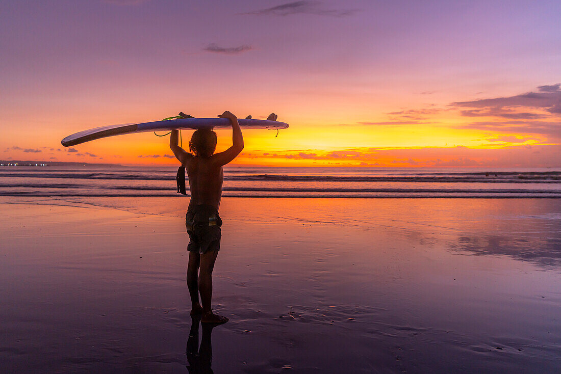 Blick auf einen Surfer am Strand von Kuta bei Sonnenuntergang, Kuta, Bali, Indonesien, Südostasien, Asien