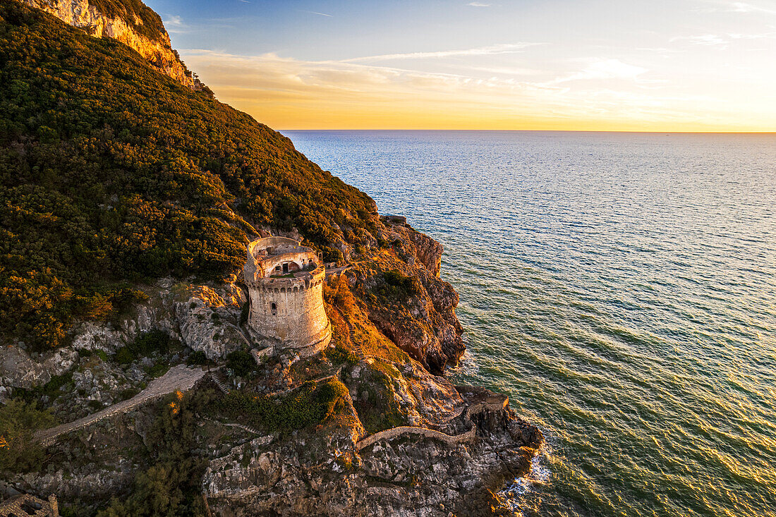 Medieval round tower standing on top of a cliff facing the sea at sunset, aerial shot, Sabaudia, Circeo National Park, Latina province, Latium, Lazio, Italy, Europe