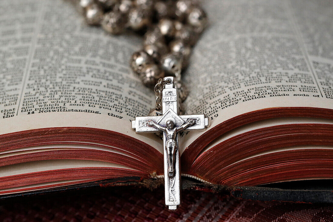Alter Rosenkranz mit Kruzifix auf einer aufgeschlagenen Bibel, christliches religiöses Symbol, Frankreich, Europa