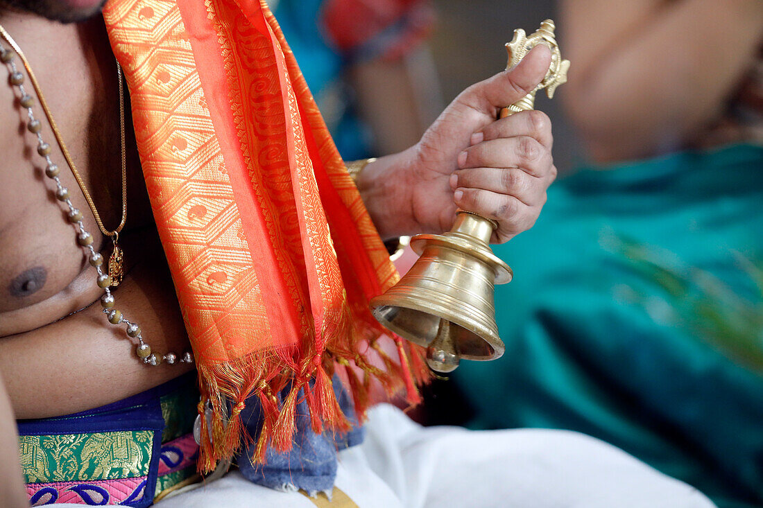 Hand hält zeremonielle Glocke, Sri Srinivasa Perumal Hindu-Tempel, Hindu-Priester (Brahmane) bei der Durchführung von Puja-Zeremonien und -Ritualen, Singapur, Südostasien, Asien