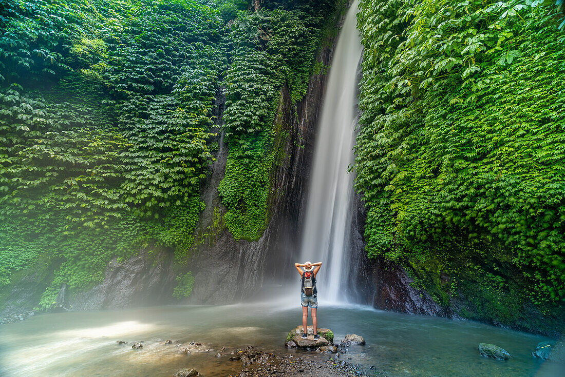 Blick auf eine Frau, die ein Foto am Melanting-Wasserfall macht, Kabupaten Buleleng, Gobleg, Bali, Indonesien, Südostasien, Asien