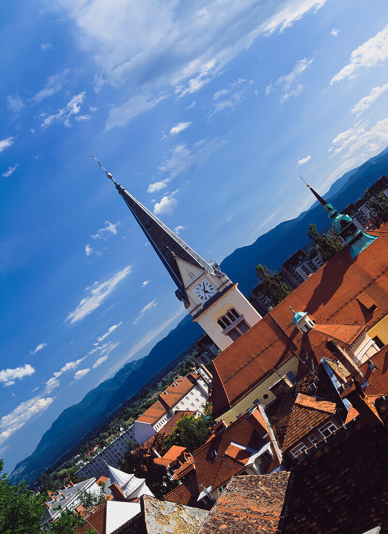 Gekippte Ansicht von Kirchenturm und Dächern.