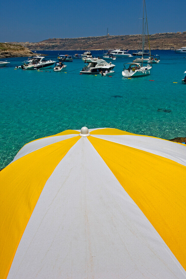 Boote vor Anker in der Blauen Lagune, Sonnenschirm im Vordergrund