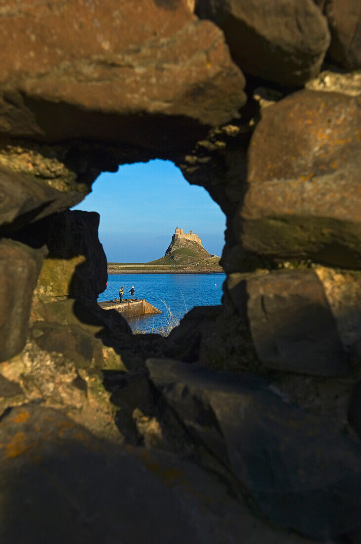 Blick durch ein Loch in einer Felswand auf Lindisfarne Castle auf Holy Island.
