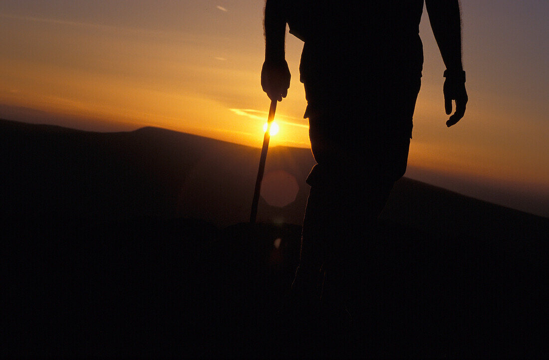 Silhouettierter Wanderer auf dem Black Mountain bei Sonnenuntergang, tiefer Blickwinkel