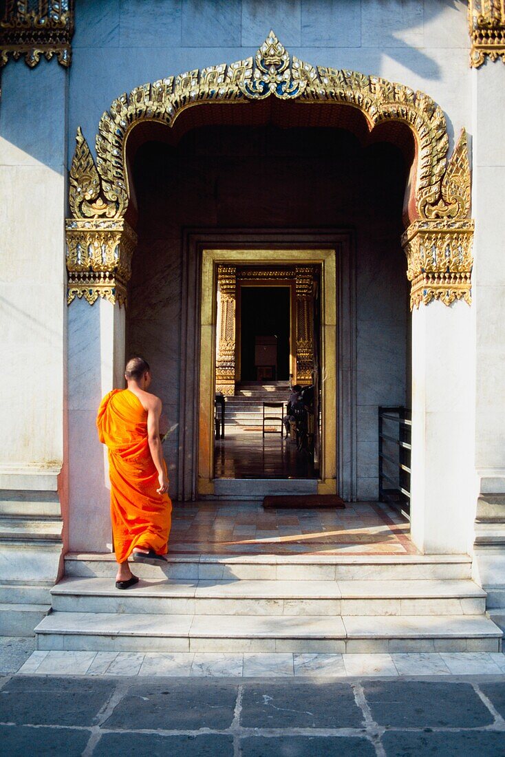 Buddhistischer Mönch, der durch das Tor des Wat Benchamabophit geht