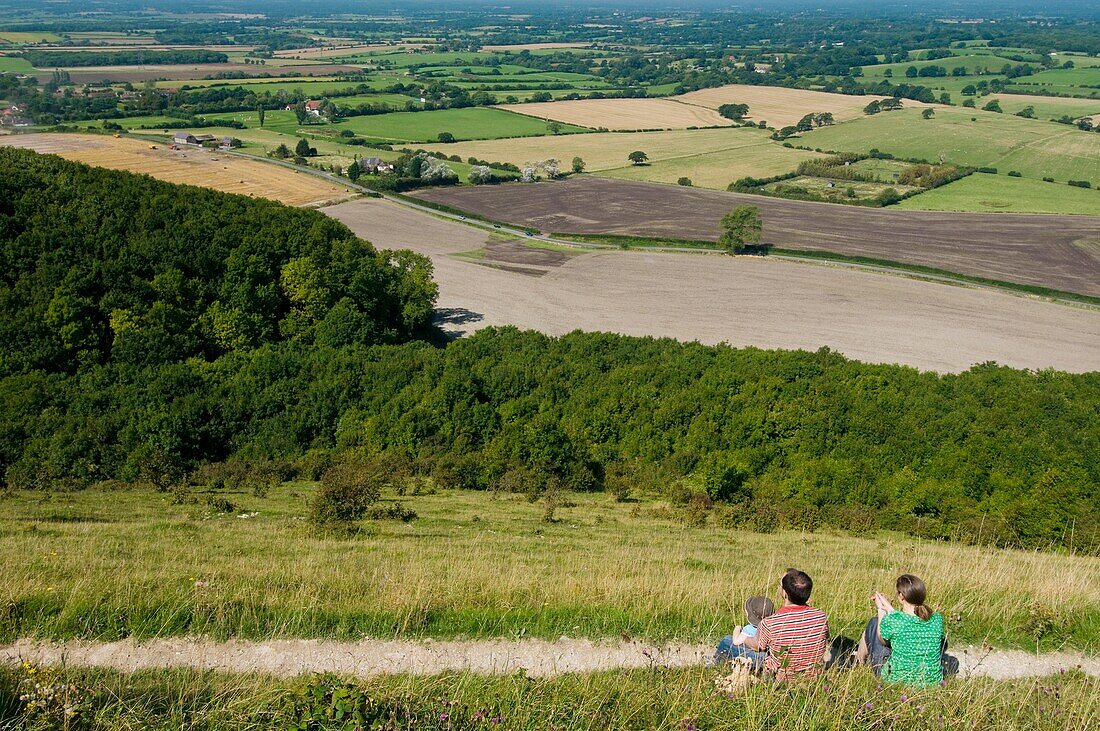 Couple With Boy Sitting On Hillside At Devil's Dyke Near Brighton