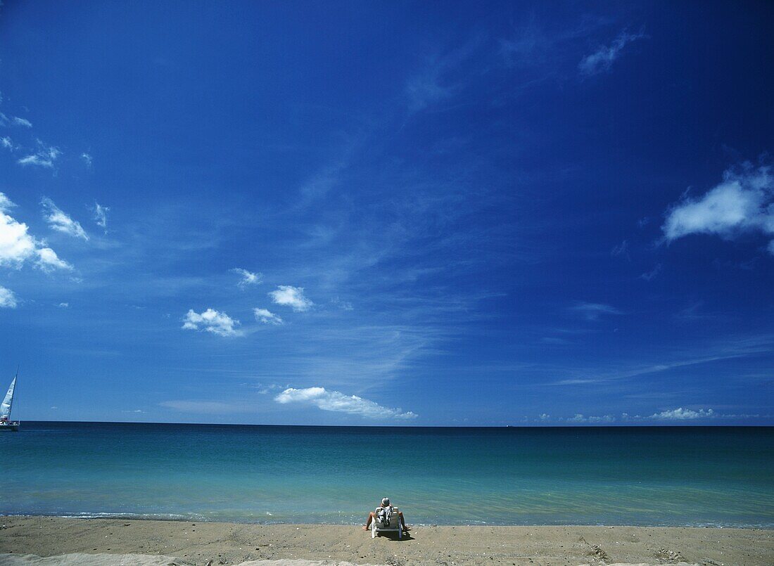 Tourist Sun-Bathing On Idyllic Sandy Beach