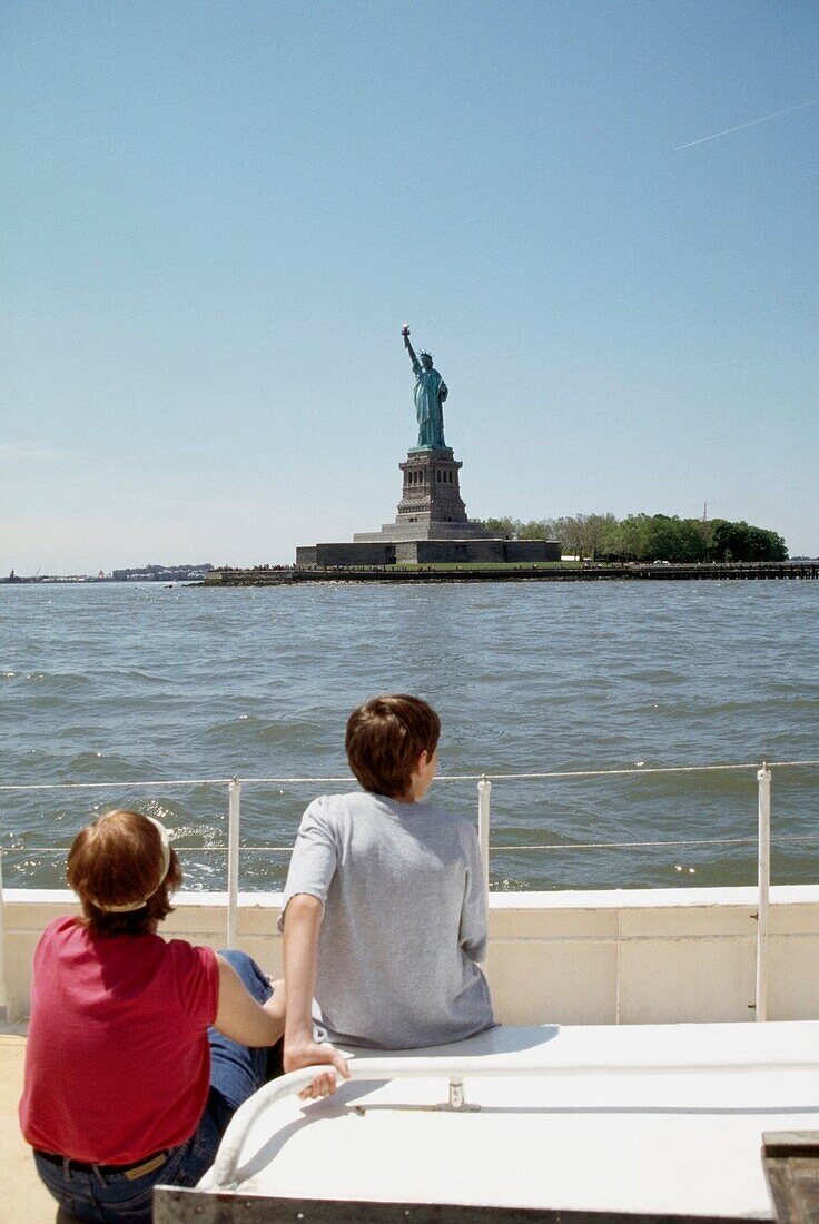 Two People On Boat, Looking At Statue Of Liberty