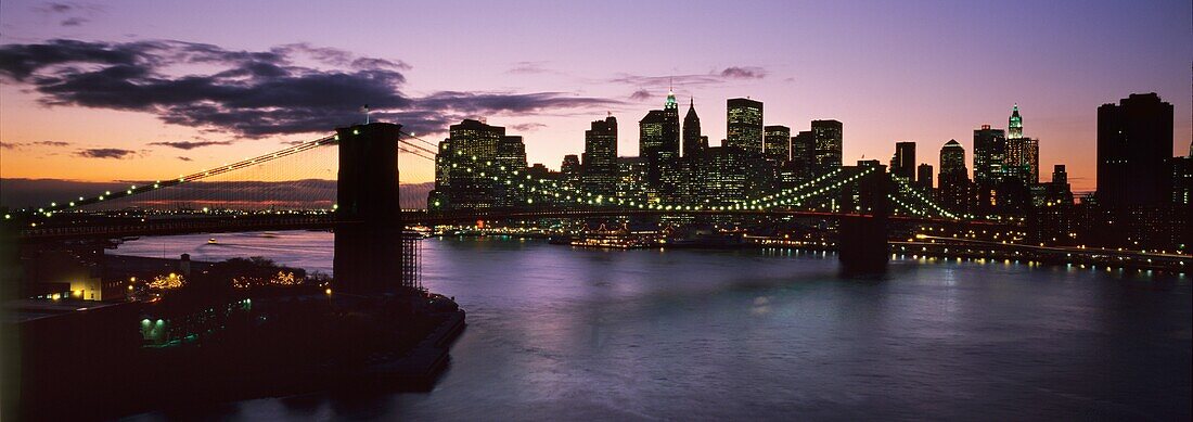 Brooklyn Bridge und Lower Manhattan in der Abenddämmerung von der Manhattan Bridge aus